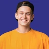 Avis d'un homme avec une casquette de face souriant.